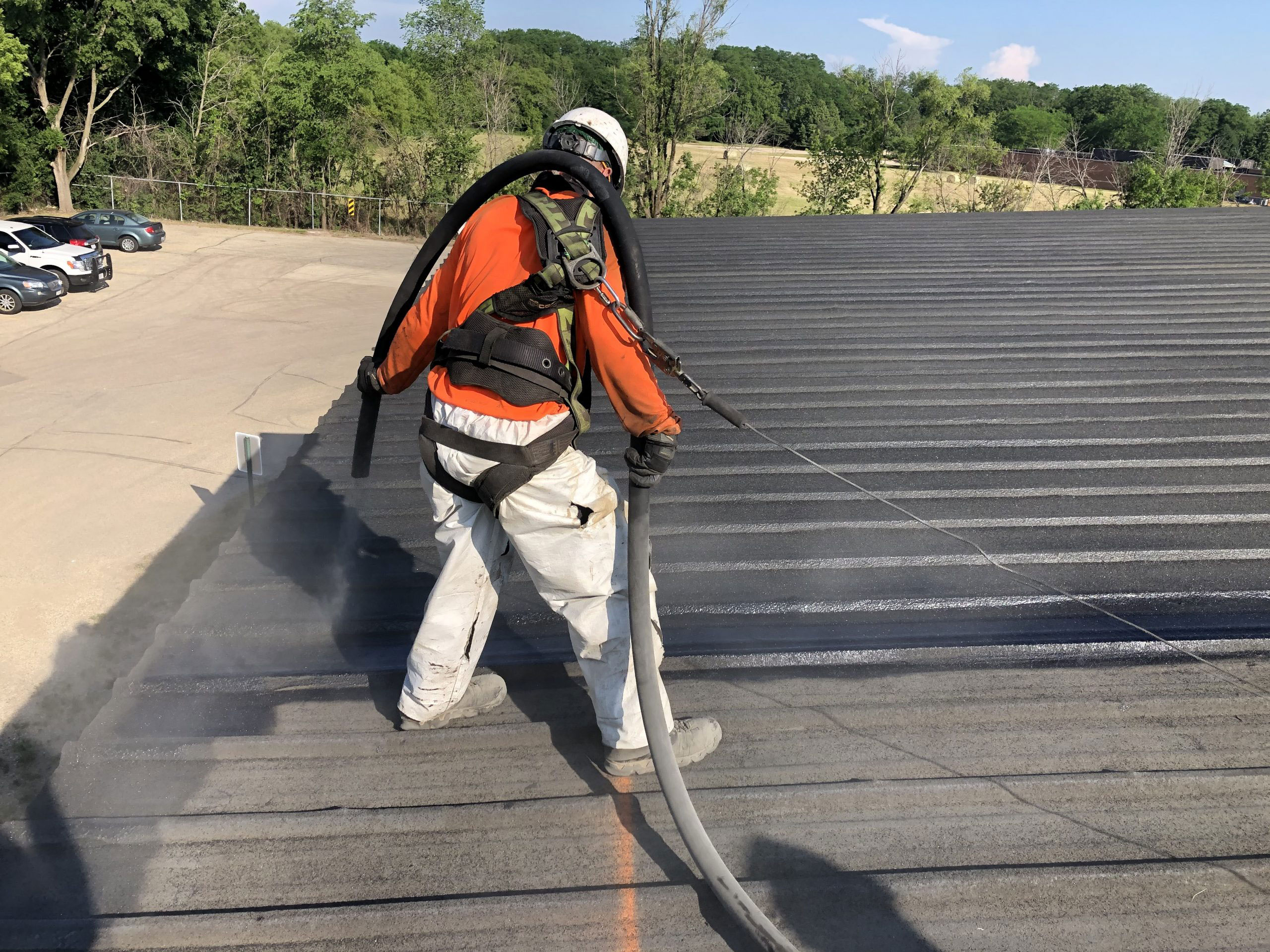 A commercial roofer performing warranty service on a metal roof.    