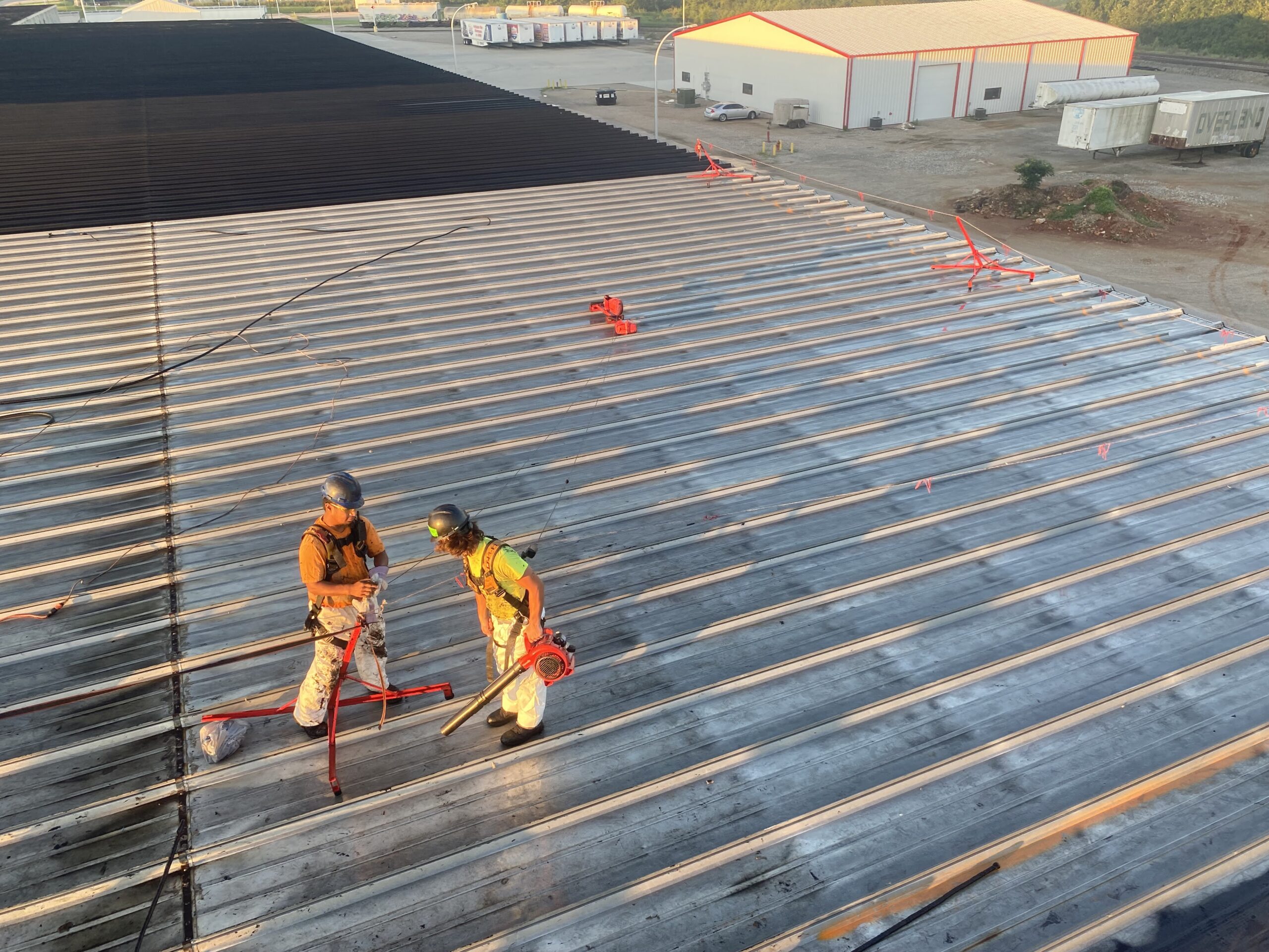 Thermal-Tec metal roof specialists work on a commercial metal roof.
