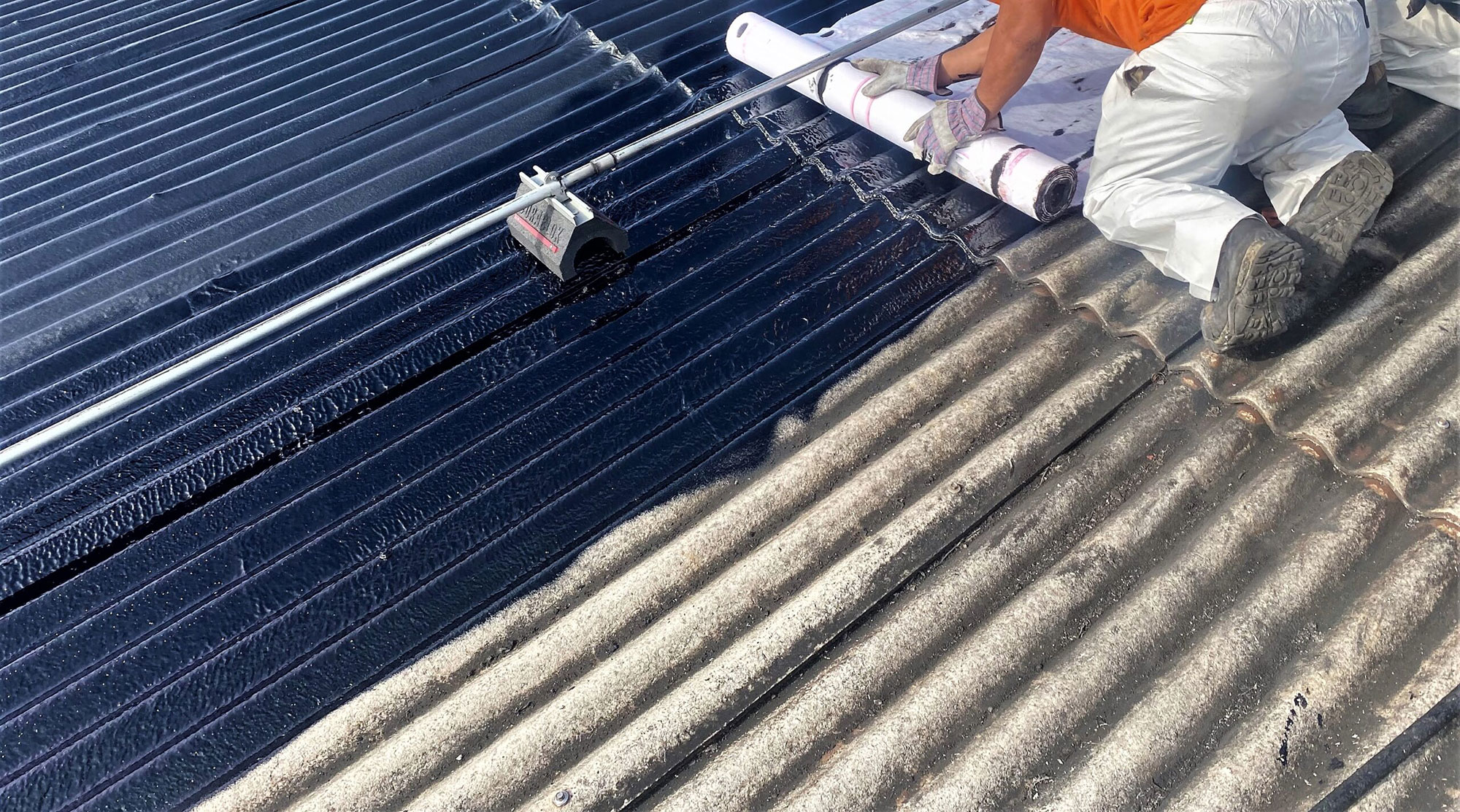 A commercial roofing crew repairing a Transite asbestos roof 